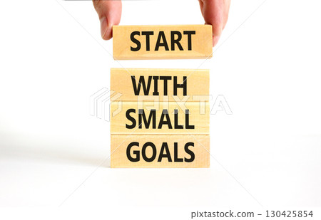 Start with small goals symbol. Concept words phrase Start with small goals on beautiful wooden blocks. Beautiful white background. Businessman's hand Business Start with small goals concept Copy space 130425854