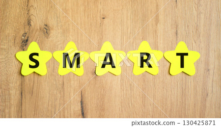 Smart symbol. Concept word Smart on beautiful yellow paper stars. Beautiful wooden table wooden background. Business lifestyle smart concept. Copy space. 130425871