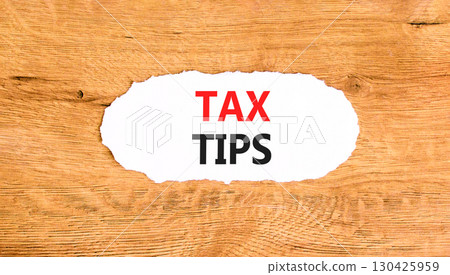 Tax tips symbol. Concept word Tax tips on beautiful white paper. Beautiful wooden paper background. Business tax tips concept. Copy space. 130425959