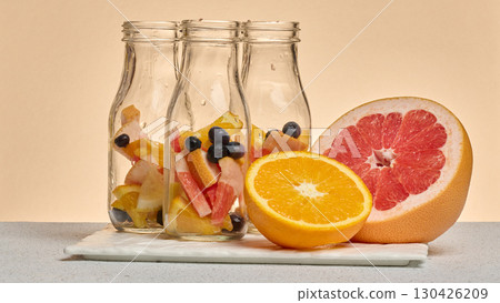 Empty glass bottles filled with citrus slices and blueberries 130426209