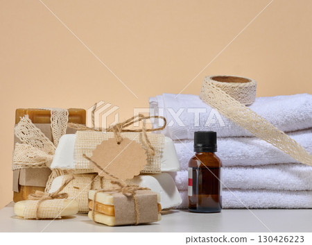 Spa and natural cosmetics items, white towels, several bars of handmade soap Spa and natural cosmetics items, white towels, several bars of handmade soap 130426223