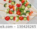 Italian appetizer with cherry tomatoes, cucumbers and mozzarella on a white board 130426265
