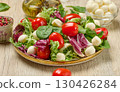 Plate of fresh salad with mixed greens, cherry tomatoes and mozzarella balls. 130426284