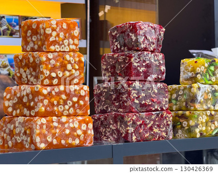 A variety of nut and fruit Turkish delights stacked on a shop counter. Tradition, culture, and sweet flavors in oriental desserts. 130426369
