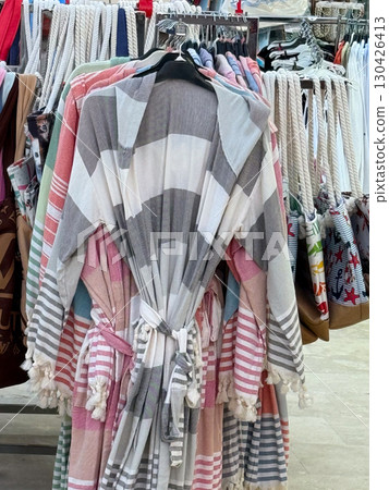 Striped robes hanging in the shop. Textile fashion, comfort, and everyday lifestyle products. Striped robes hanging in the shop. Textile fashion, comfort, and everyday lifestyle products. 130426413