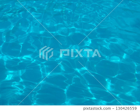 Blue water surface with sunlight reflections in a swimming pool. Leisure, recreation and summer lifestyle represented through clarity, refreshment and aquatic relaxation. Blue water surface with sunlight reflections in a swimming pool. Leisure, recreation and summer lifestyle represented through clarity, refreshment and aquatic relaxation. 130426559