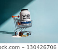 Whey protein container in shopping cart with spilled fish oil capsules and powder on pastel blue background, symbolizing fitness and nutrition 130426706