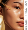 Glowing skin with drop of serum from golden dropper in close-up view representing healthy skincare and moisture 130426821