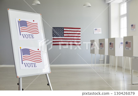 Interior of an election station with a VOTE sign, polling booths and the American flag 130426879