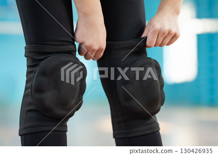 Girl putting protector pads on her knees. Volleyball training on the court, protecting your body from injuries 130426935