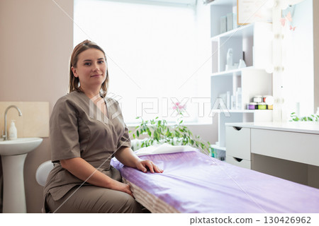 Portrait of a professional beautician in her cabinet ready to welcome next patient client and perform some spa procedures to them. Doctor cosmetologist waiting for a patient Portrait of a professional beautician in her cabinet ready to welcome next patient client and perform some spa procedures to them. Doctor cosmetologist waiting for a patient 130426962