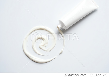 Elegant cream tube with luxurious swirl of lotion on a white surface, skincare and beauty product Elegant cream tube with luxurious swirl of lotion on a white surface, skincare and beauty product 130427123