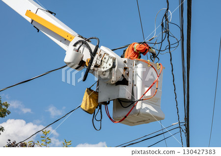 Electrical utility worker in bucket lift working on power lines maintenance 130427383