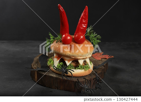Halloween food concept. Scary hamburgers with fresh parsley leaves, tomatoes, cream cheese, onion and cutlet on old concrete background, low key, food delivery, cafe advertisement, 130427444