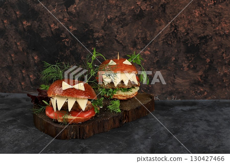 Halloween food concept.Two burgers with fresh parsley leaves, tomatoes, cream cheese, onions and cutlet on old concrete background, low key, food delivery, cafe advertisement, 130427466
