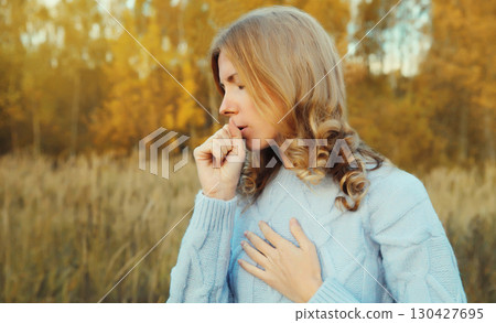Cold and health, sick young woman coughing outdoors in autumn park, fall season 130427695