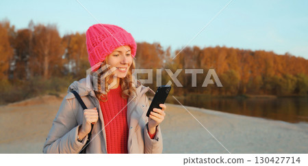 Travel, adventure, traveler woman with phone on the beach, girl holding smartphone on sea coast Travel, adventure, traveler woman with phone on the beach, girl holding smartphone on sea coast 130427714