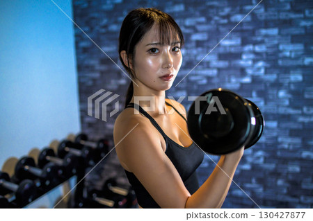 Woman lifting dumbbells, cool woman exercising at the gym, dumbbell curl, muscle training girl Woman lifting dumbbells, cool woman exercising at the gym, dumbbell curl, muscle training girl 130427877