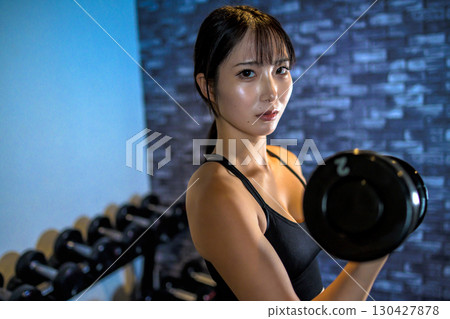 女人舉啞鈴,酷女人在健身房鍛煉,啞鈴捲曲,肌肉訓練女孩 女人舉啞鈴,酷女人在健身房鍛煉,啞鈴捲曲,肌肉訓練女孩 130427878