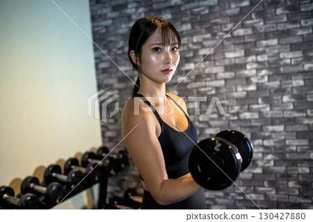 Woman lifting dumbbells, cool woman exercising at the gym, dumbbell curl, muscle training girl Woman lifting dumbbells, cool woman exercising at the gym, dumbbell curl, muscle training girl 130427880
