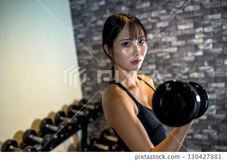 Woman lifting dumbbells, cool woman exercising at the gym, dumbbell curl, muscle training girl Woman lifting dumbbells, cool woman exercising at the gym, dumbbell curl, muscle training girl 130427881