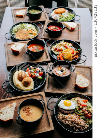Assorted homemade lunch dishes on wooden trays served in cozy rustic restaurant setting Assorted homemade lunch dishes on wooden trays served in cozy rustic restaurant setting 130428135