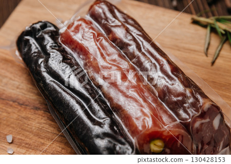 Three types of gourmet sausages in vacuum packaging on wooden board with rustic background Three types of gourmet sausages in vacuum packaging on wooden board with rustic background 130428153