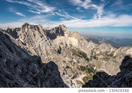 Scenic View Of Zugspitze And Jubilee Ridge From Via Ferrata Alpspitze: Rugged Rocky Peaks Of The Bavarian Alps Under Clear Blue Sky 130428388