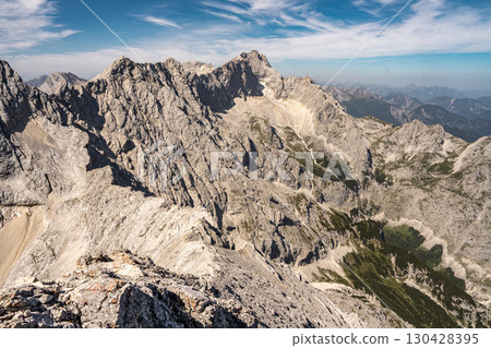 Scenic View Of Zugspitze And Jubilee Ridge From Via Ferrata Alpspitze: Rugged Rocky Peaks Of The Bavarian Alps Under Clear Blue Sky Scenic View Of Zugspitze And Jubilee Ridge From Via Ferrata Alpspitze: Rugged Rocky Peaks Of The Bavarian Alps Under Clear Blue Sky 130428395
