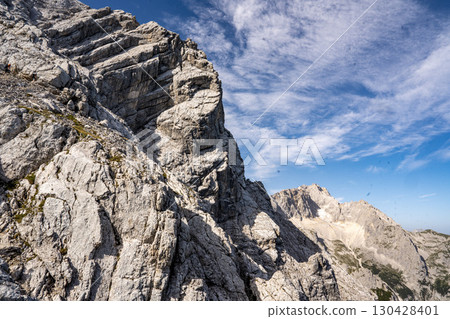 Rocky Section Of The Via Ferrata Alpspitze In The Bavarian Alps: Dramatic Cliffs And Mountain Peaks Under Scenic Blue Sky 130428401