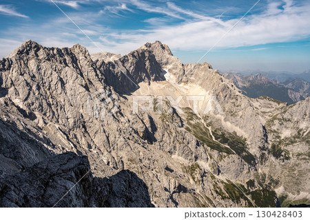 Scenic View Of Zugspitze And Jubilee Ridge From Via Ferrata Alpspitze: Rugged Rocky Peaks Of The Bavarian Alps Under Clear Blue Sky 130428403