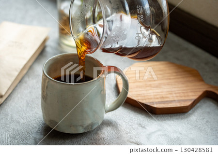 在光影中將咖啡倒入杯中 在光影中將咖啡倒入杯中 130428581