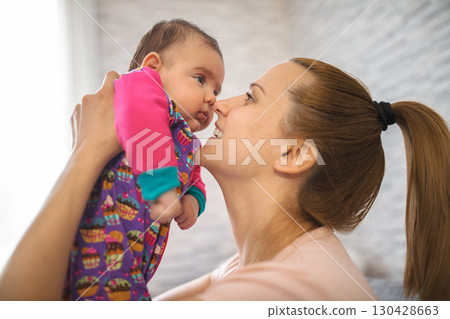 Loving mother playing with her newborn baby girl at home 130428663