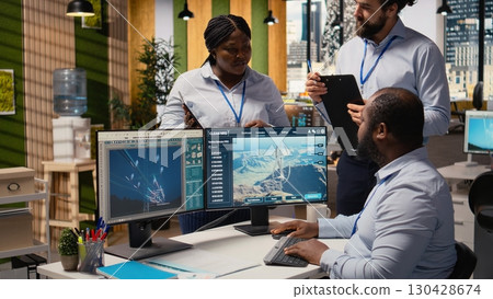 Team of engineers brainstorming how to optimize electric grid and wind farm layout to produce more green energy. RD office coworkers do power lines and futuristic wind turbine simulation, camera A 130428674