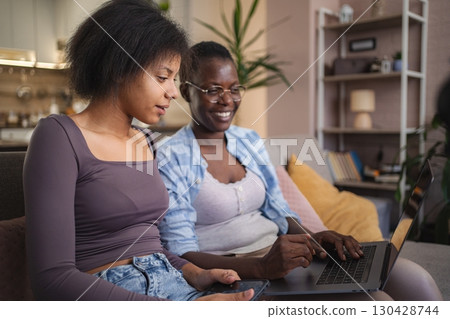 Two Young Women Working on Laptop at Home Two Young Women Working on Laptop at Home 130428744