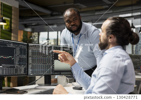 Manager supervising day trader using trading app to capitalize on market fluctuations when buying and selling stocks. Prop firm office team leader and expert identifying profit opportunities Manager supervising day trader using trading app to capitalize on market fluctuations when buying and selling stocks. Prop firm office team leader and expert identifying profit opportunities 130428771