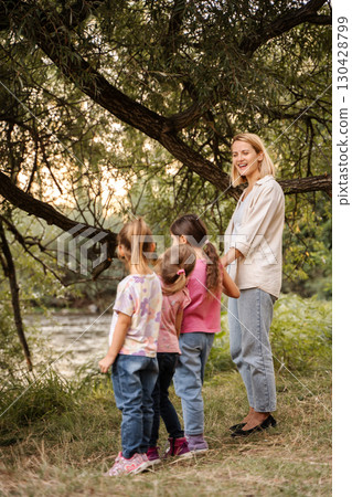 Teacher and preschool age children enjoying nature near river 130428799