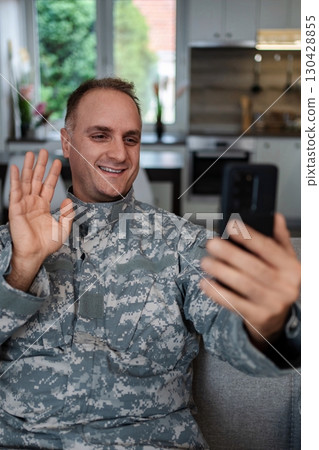 Happy soldier making a video call with family from home Happy soldier making a video call with family from home 130428855