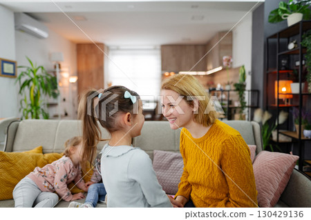Loving mother spending time with her daughters at home 130429136