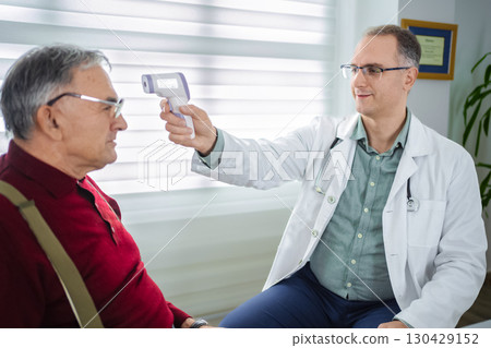 A doctor conducts a health assessment for an elderly man in a clinic A doctor conducts a health assessment for an elderly man in a clinic 130429152