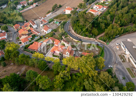 Aerial view of winding road passing through green 130429292