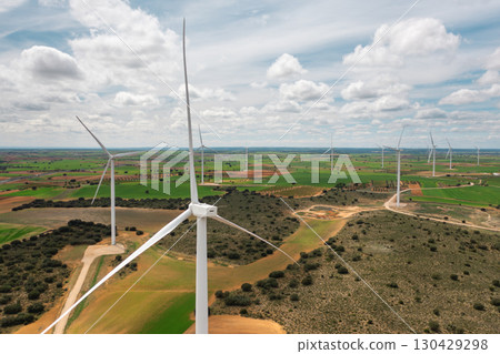 Wind turbines across green and brown farmlands 130429298