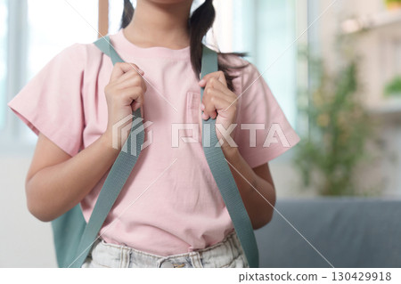 Child adjusting backpack straps before school Child adjusting backpack straps before school 130429918