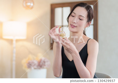 Woman holding a perfume bottle Woman holding a perfume bottle 130429937