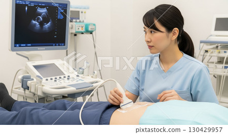 A female nurse performing an abdominal ultrasound examination on a male patient 130429957