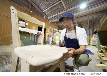 A craftsman gluing pieces together during the furniture assembly process 130430239