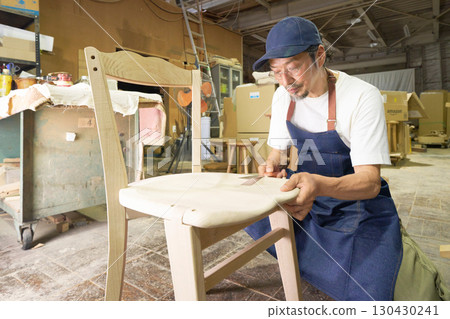 A veteran craftsman fine-tuning the details during the furniture-making process 130430241