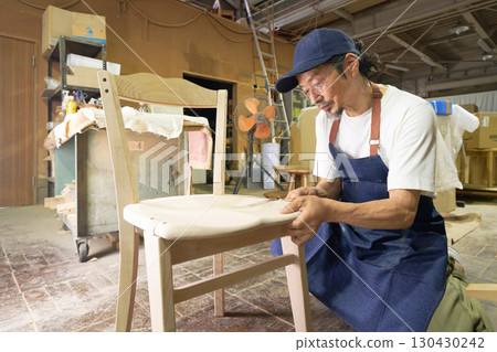 A veteran craftsman fine-tuning the details during the furniture-making process 130430242