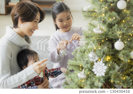 Families decorating Christmas trees 130430438