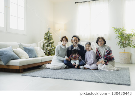 Families decorating Christmas trees 130430443